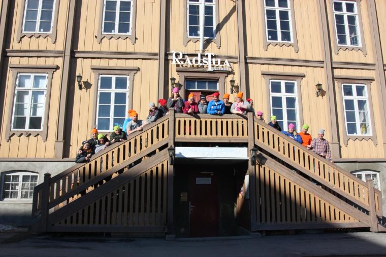 folk som står på trappa på Rådstua teaterhus med luer der det står HATS